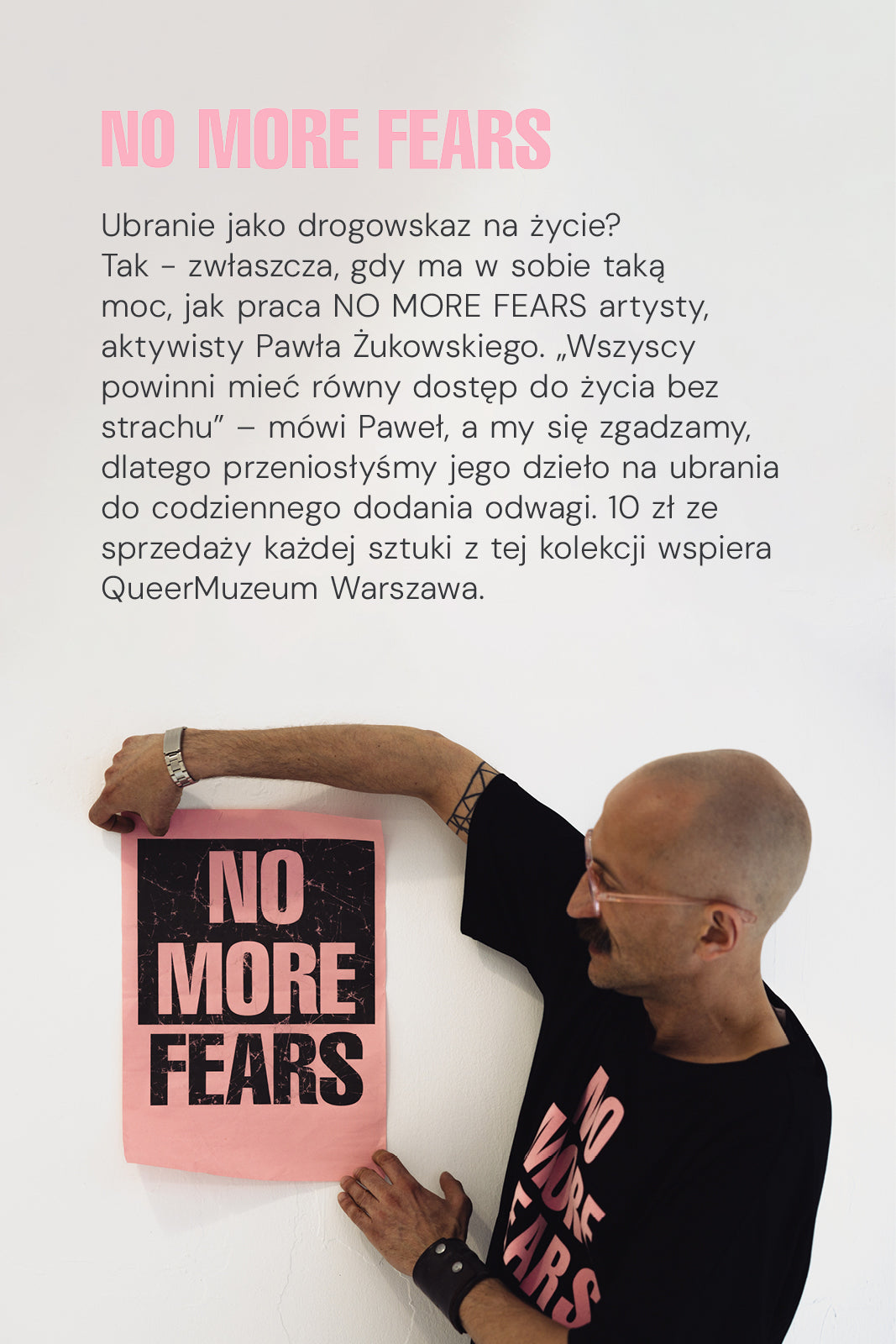 Mężczyzna w czarnej koszulce z napisem NO MORE FEARS trzyma plakat z tym samym hasłem, wspierając QueerMuzeum Warszawa.