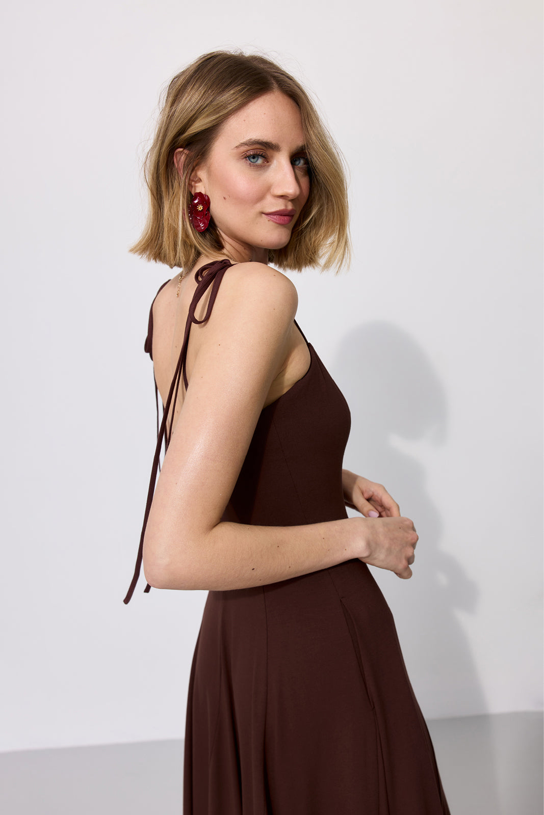 Elegancka sukienka w kolorze burgundowym z wiązanymi ramiączkami, idealna na wieczór. Moda polska, precyzyjne krawiectwo.