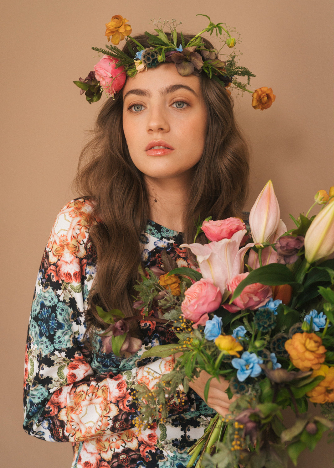 Kobieta w kwiecistej sukience z wiankiem kwiatów, trzymająca bukiet róż i lilii – moda polska, self-care fashion