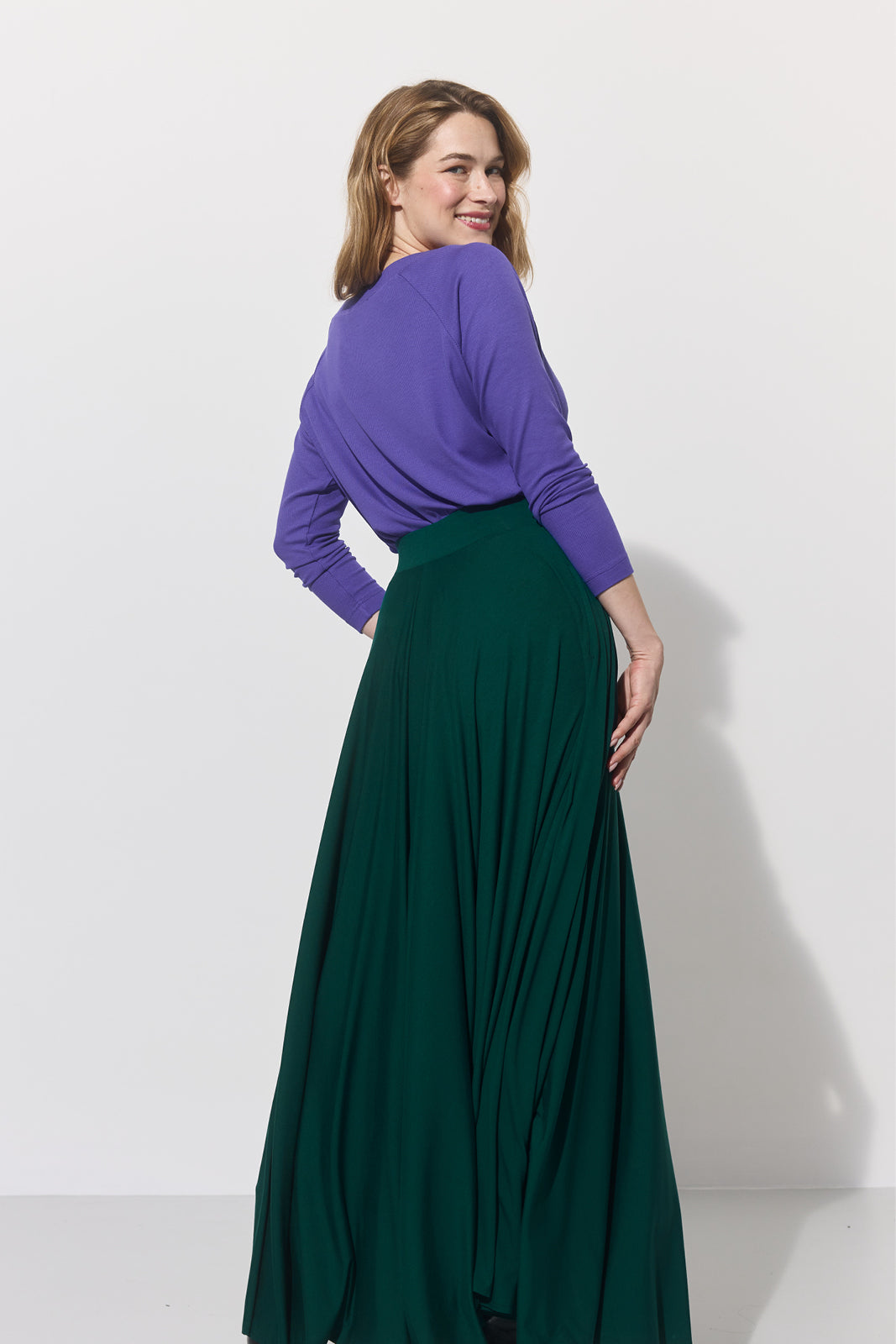 Fioletowy sweter i zielona spódnica maxi – elegancka stylizacja damska z precyzyjnym krojem