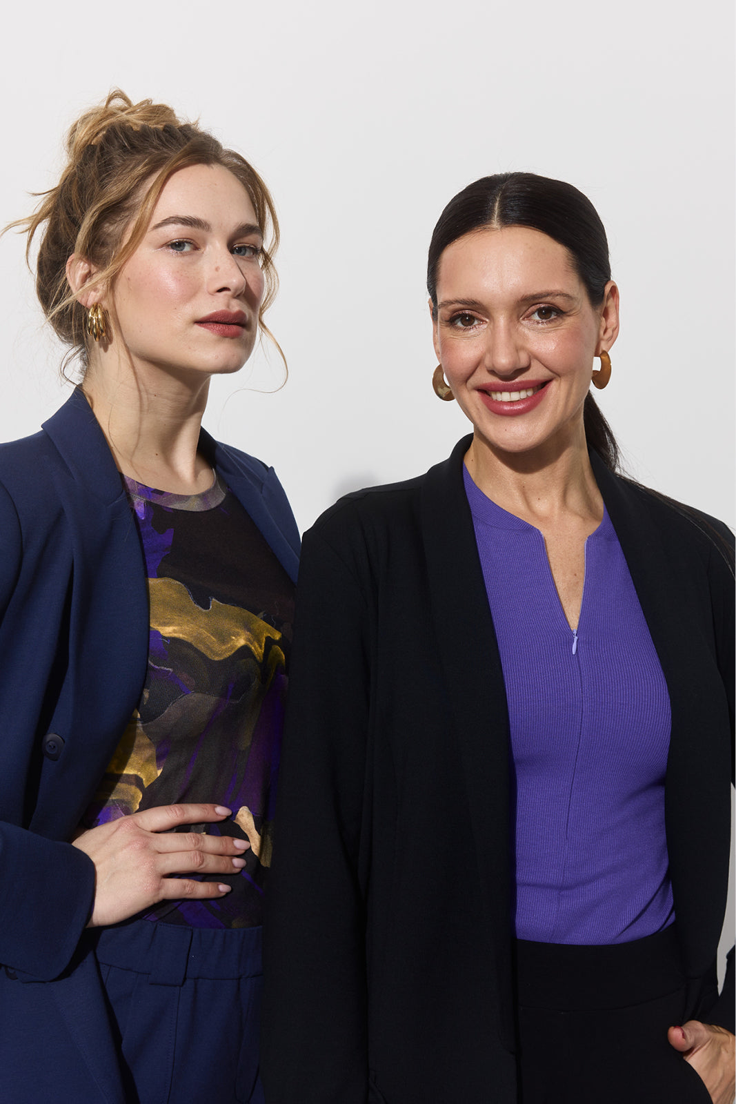 Dwie kobiety w eleganckich bluzach i marynarkach, stylowa odzież damska z precyzyjnym krojem