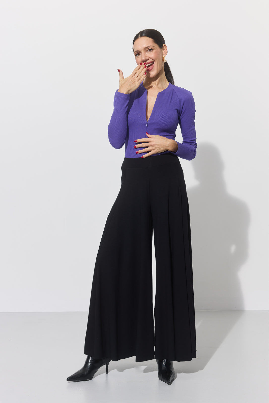 Fioletowa bluzka z zamkiem i czarne spodnie w stylu self-care fashion, idealne na co dzień