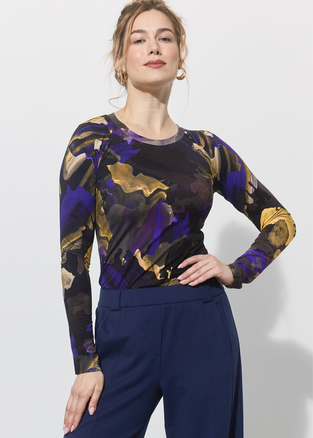 Kobieta w stylowej bluzce z abstrakcyjnym wzorem i granatowych spodniach, moda z kulturą i wygodą