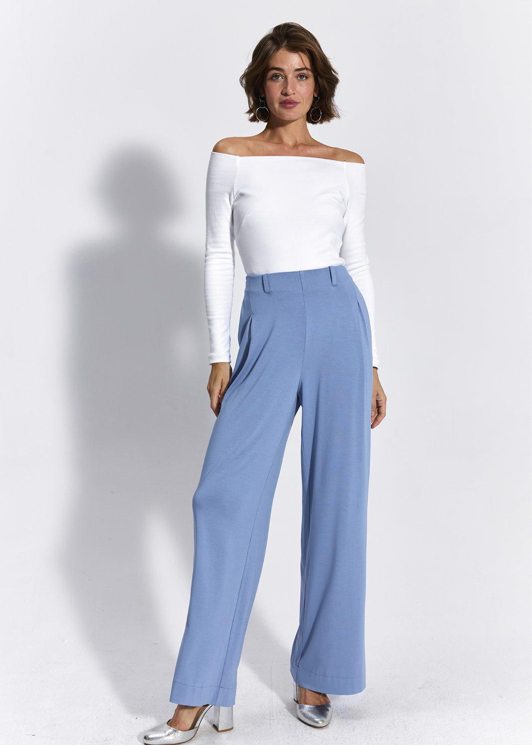 Białe top z odkrytymi ramionami i niebieskie spodnie wide leg – elegancka stylizacja damska
