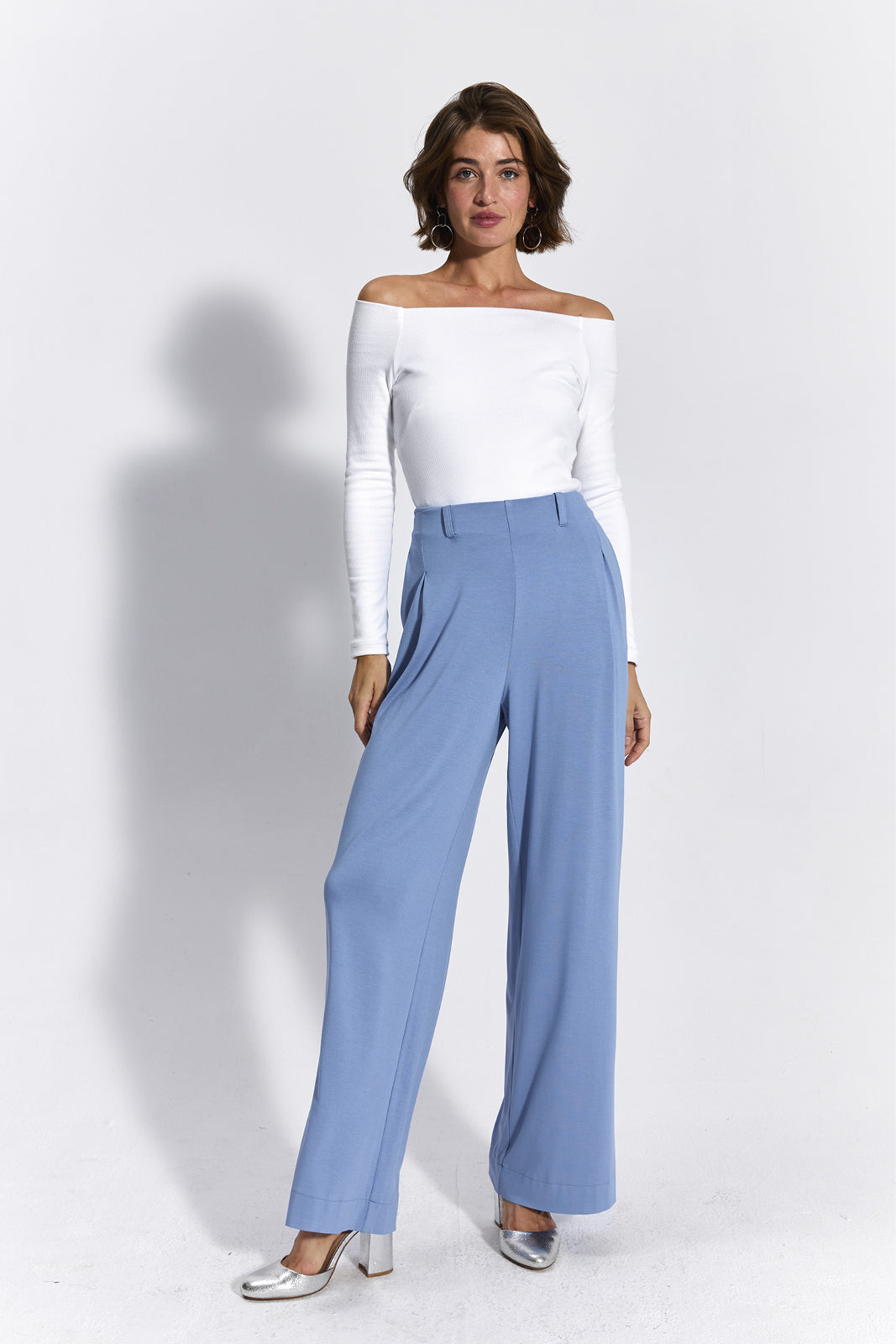 Białe top z odkrytymi ramionami i niebieskie spodnie wide leg – elegancka stylizacja damska