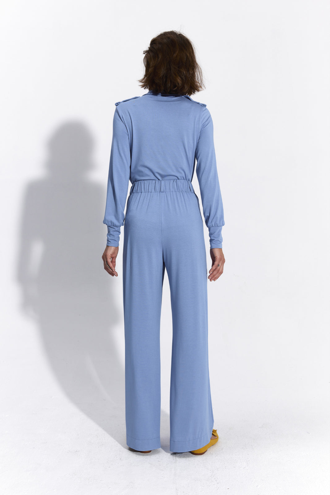 Niebieski jumpsuit z długim rękawem i elastyczną talią, idealny na co dzień – wygodna moda damska