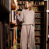 Kobieta w beżowej sukience w bibliotece, stylowy strój na co dzień, wygodna moda