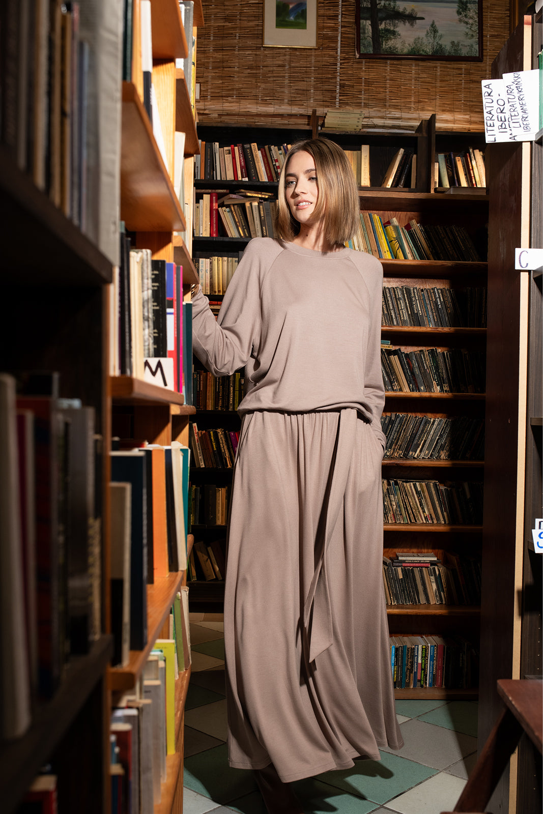 Kobieta w beżowej sukience w bibliotece, stylowy strój na co dzień, wygodna moda