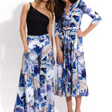 Dwie kobiety w modnych, kolorowych sukienkach i spodniach z abstrakcyjnym wzorem, idealne na letni styl i self-care fashion