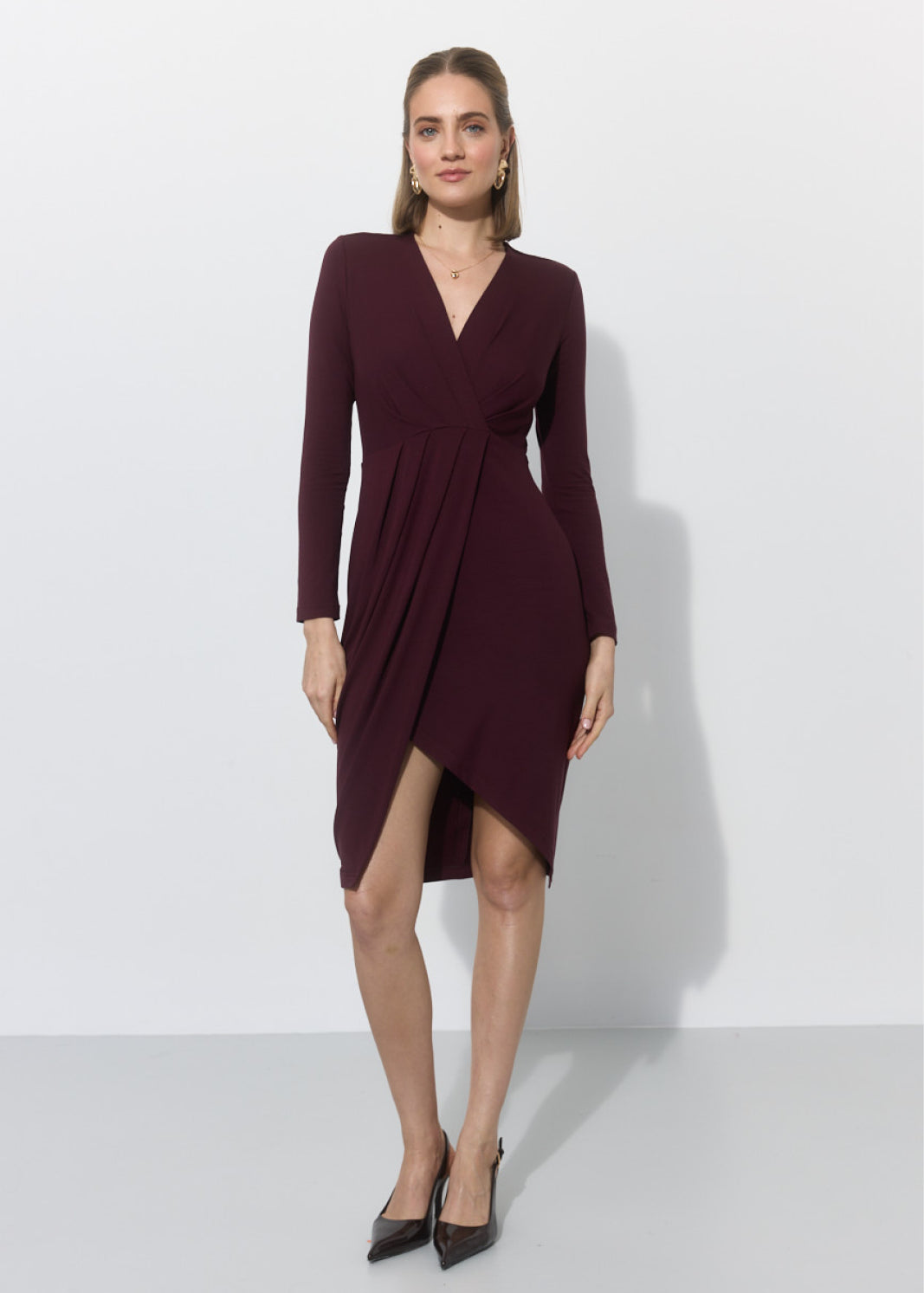 Elegancka sukienka w kolorze bordo z asymetryczną linią do kolan, idealna na codzienne stylizacje